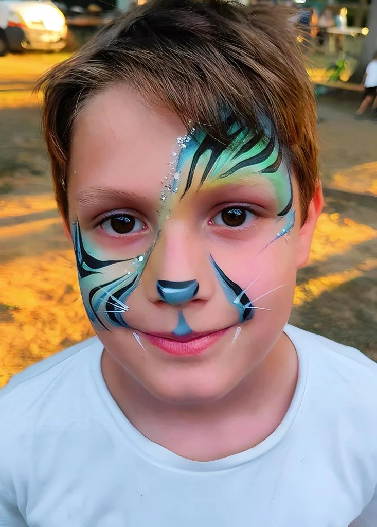 Face painting tigre bleu et vert sur visage de garçon - kermesse et fête